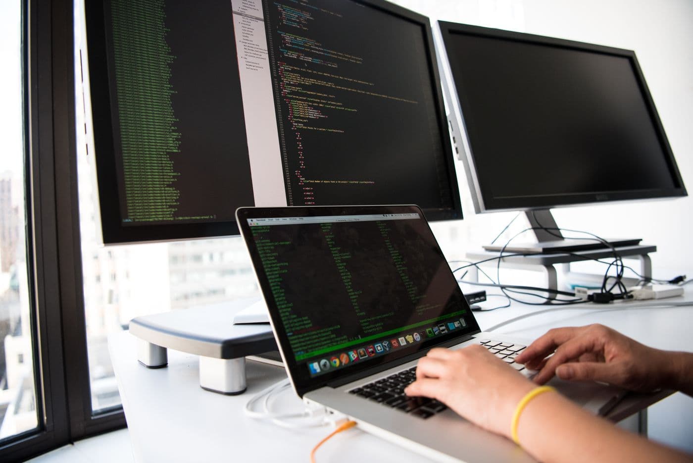 Developer workstation with multiple monitors and a laptop